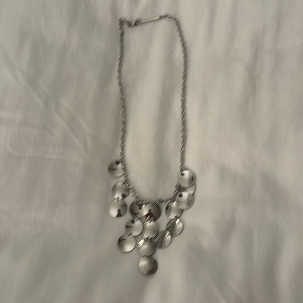 Silver necklace with silver discs hanging off of chain